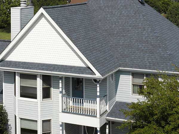 Front view of a typical mid-class home with dark gray CertainTeed shingles on its roof
