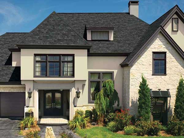 Front view of a typical mid-class home with charcoal black GAF shingles on its roof